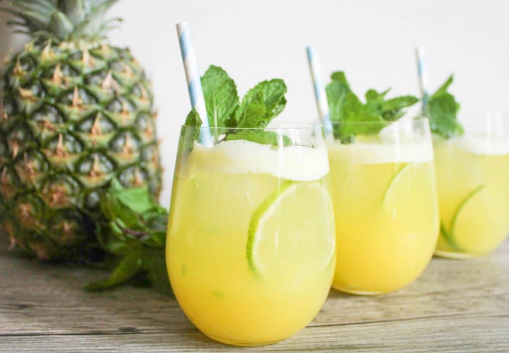 Three glasses of pineapple Ginger mojito garnished with mint. 