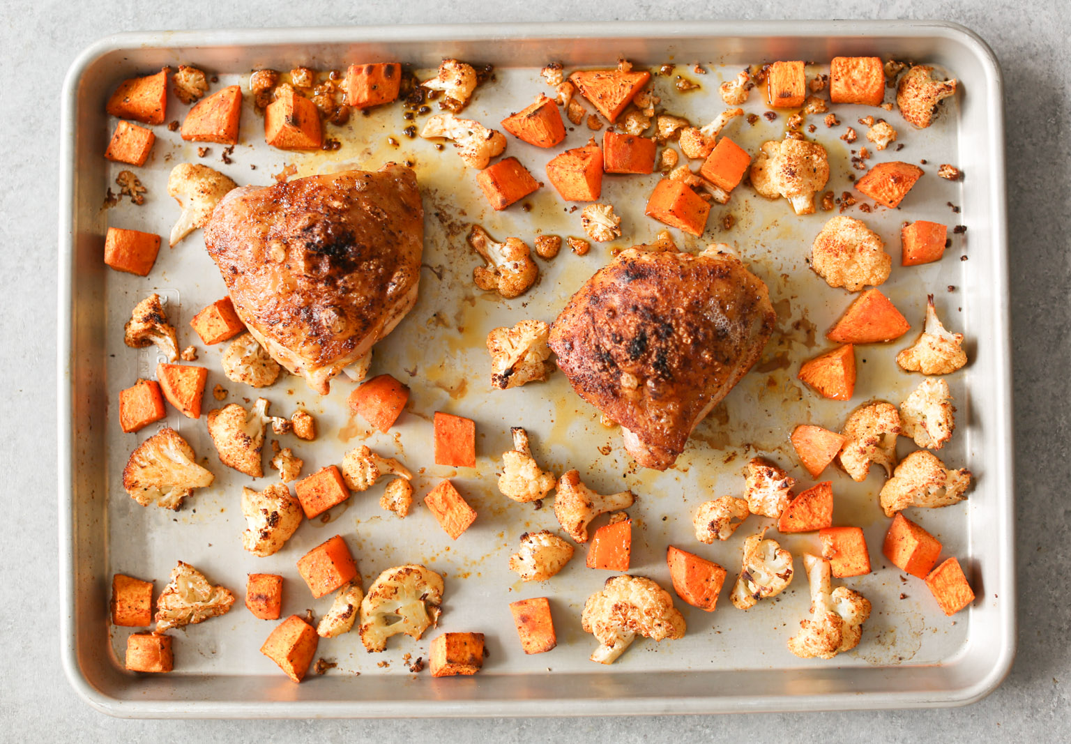 Sheet Pan Chicken Thighs with Cauliflower, Sweet Potatoes, and Pomegranate
